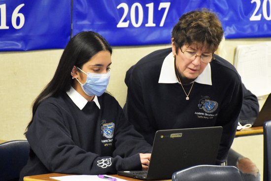 Middle College students Gurmannat Chalotra and AD Coach Janet Bengtson wrestle with a difficult economics problem during Academic Decathlon.